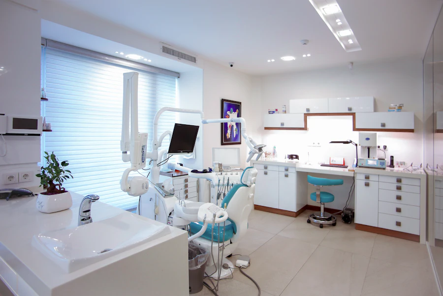 A bright, modern dental treatment room with a teal patient chair