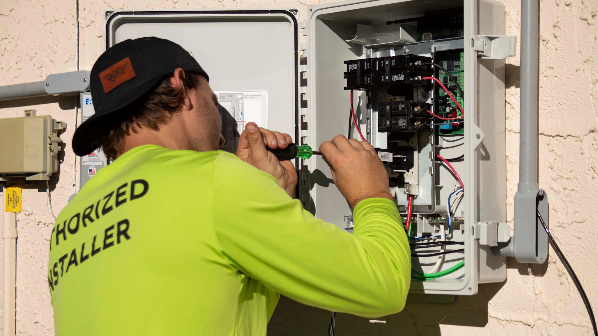 Copperline technician tightening a breaker in an outdoor electrical panel
