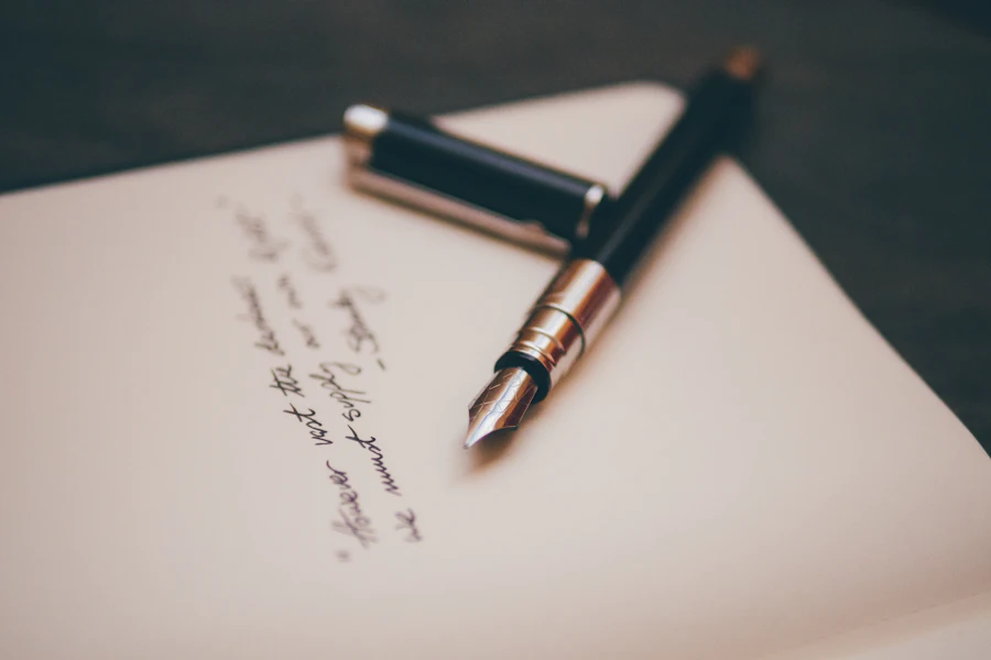 A fountain pen resting on a handwritten letter